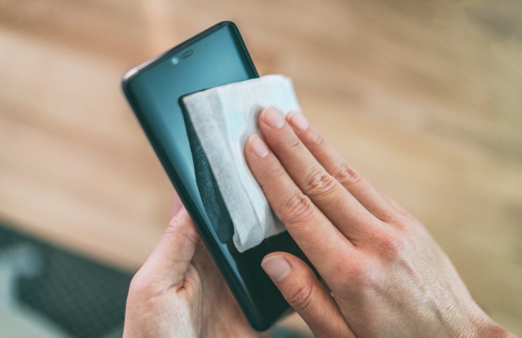 Pulizia dello schermo di uno smartphone in corso