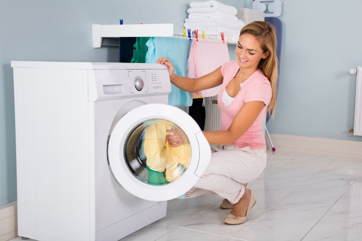 donna che tira fuori panni dall'asciugatrice