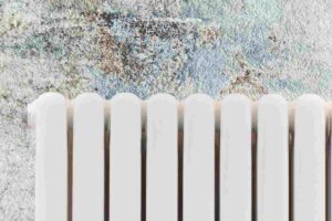 Termosifone e muro macchiato alle sue spalle