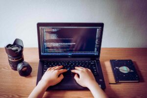 mani che scrivono codici su un computer
