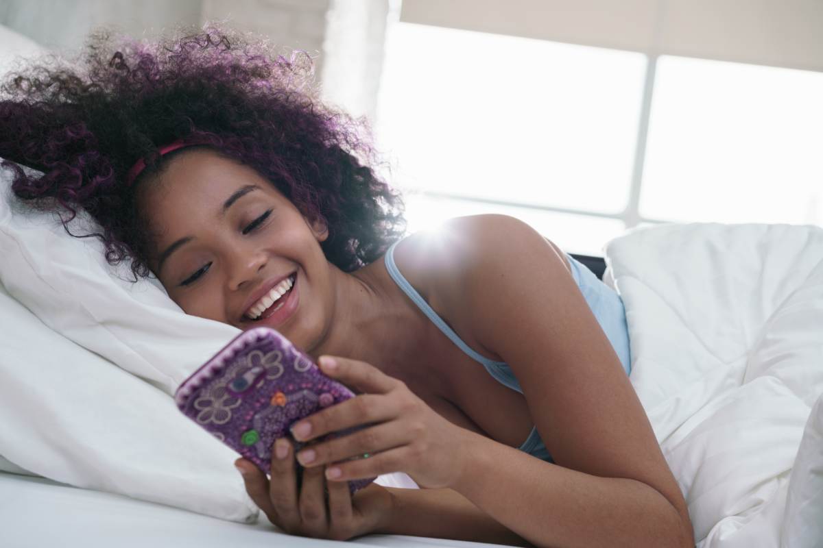 ragazza usa telefono a letto